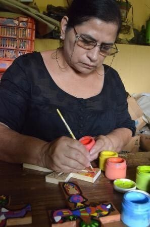 A picture of Lita painting a wooden cross